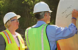 Sen. Thomas Carper signs one of the turbine's blades
as Dean Nancy Targett looks on.